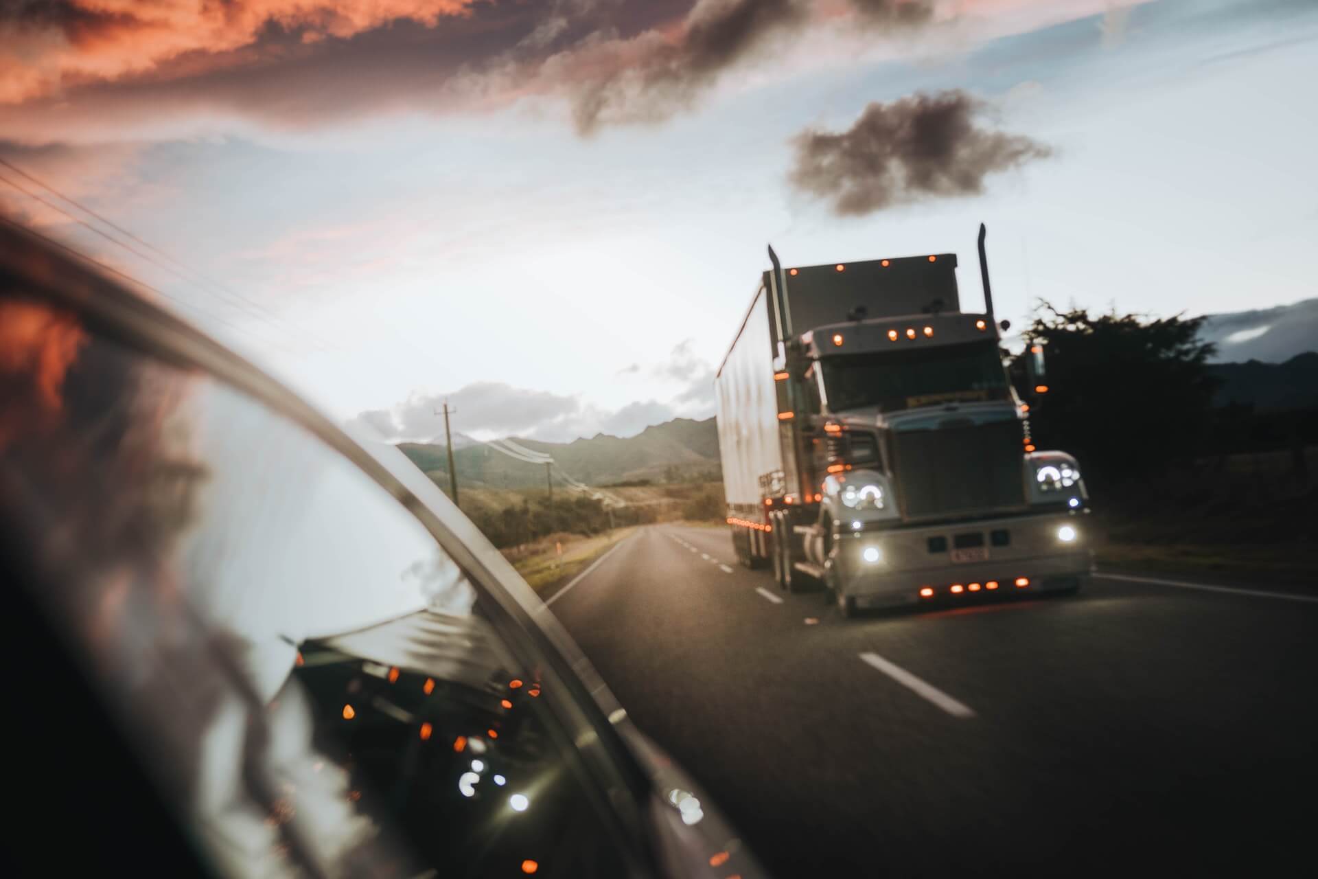 Truck driving behind a car on open road