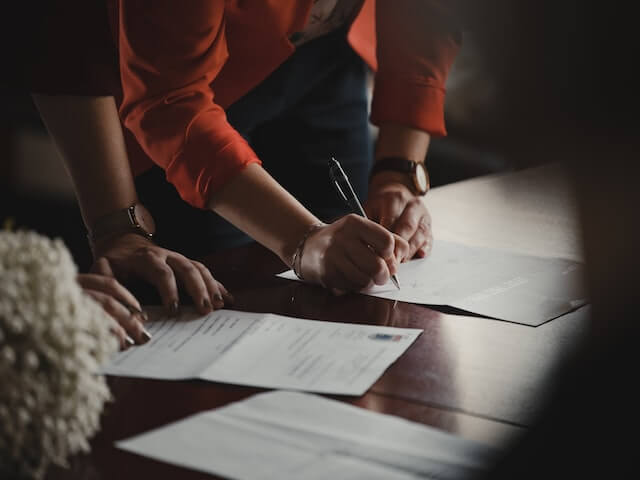 People reviewing and signing papers.